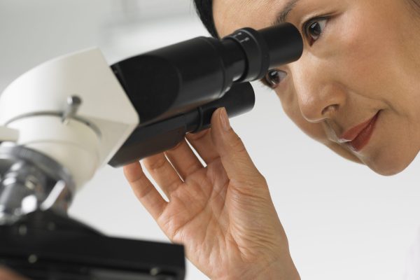 Scientist looking into a microscope